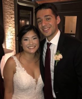 Color photo of the bride and groom at the reception taken from the waist up.