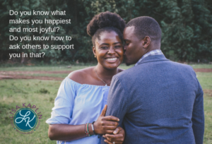 A color photo of a Black couple in a loose embrace. The woman is facing the camera and smiling. The man has his back to the camera and is kissing the woman on the cheek. At the top left of the image is the text “Do you know what makes you happiest and most joyful? Do you know how to ask others to support you in that?” The Lisa Kaplin logo is beneath the text.