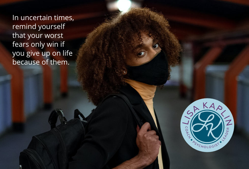 A color photo of a Black person with natural hair, wearing a mask, carrying a backpack, and looking at the camera with a stressed look on their face. The text is to their left reads “In uncertain times, remind yourself that your worst fears only win if you give up on life because of them.” The Lisa Kaplin logo is on the right side of the image.