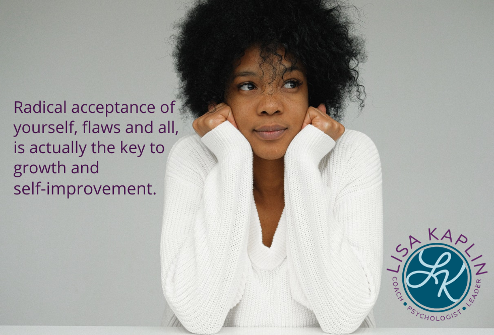 A color photo of a Black woman with natural hair wearing a white sweater. She has her elbows on the table and is resting her head on her hands as she looks contemplatively to the right. The text to her left reads “Radical acceptance of yourself, flaws and all, is actually the key to growth and self-improvement.” The Lisa Kaplin logo is in the lower right corner.