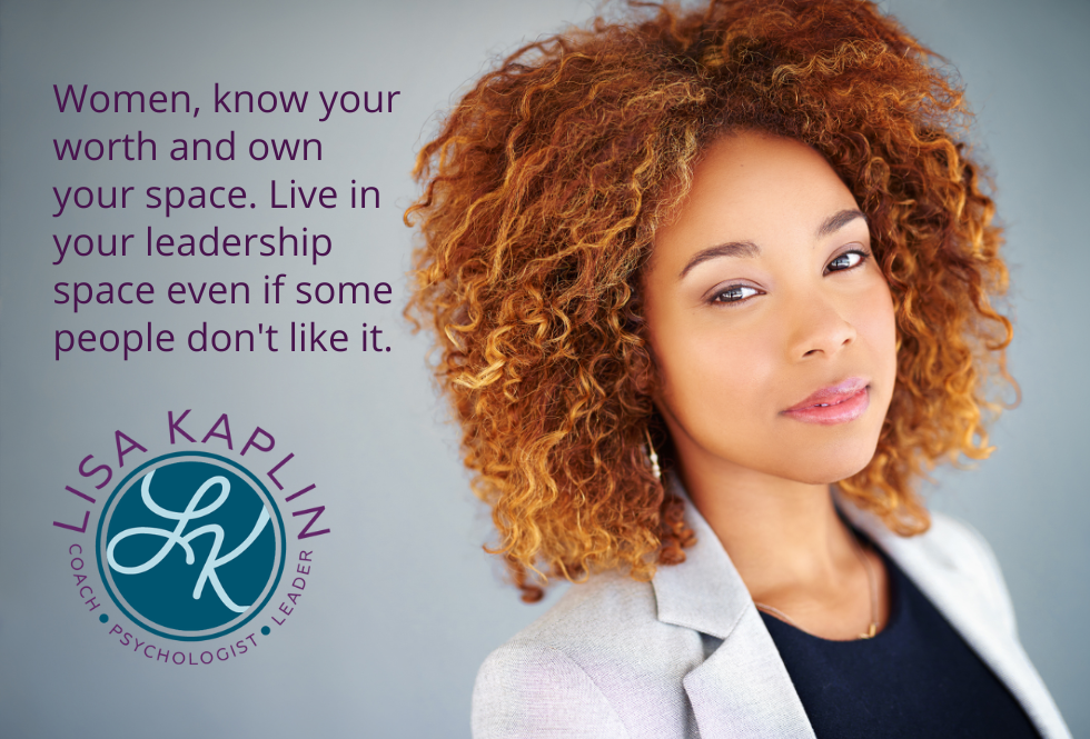 A color headshot-style photo of a young professional Black woman looking directly at the camera. She has shoulder length red hair with natural curls. The text to her left reads “Women, know your worth and own your space. Live in your leadership space even if some people don't like it.” The Lisa Kaplin logo is beneath the text.